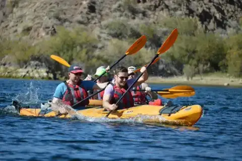 Group paddling a multi-person kayak on the Colorado River