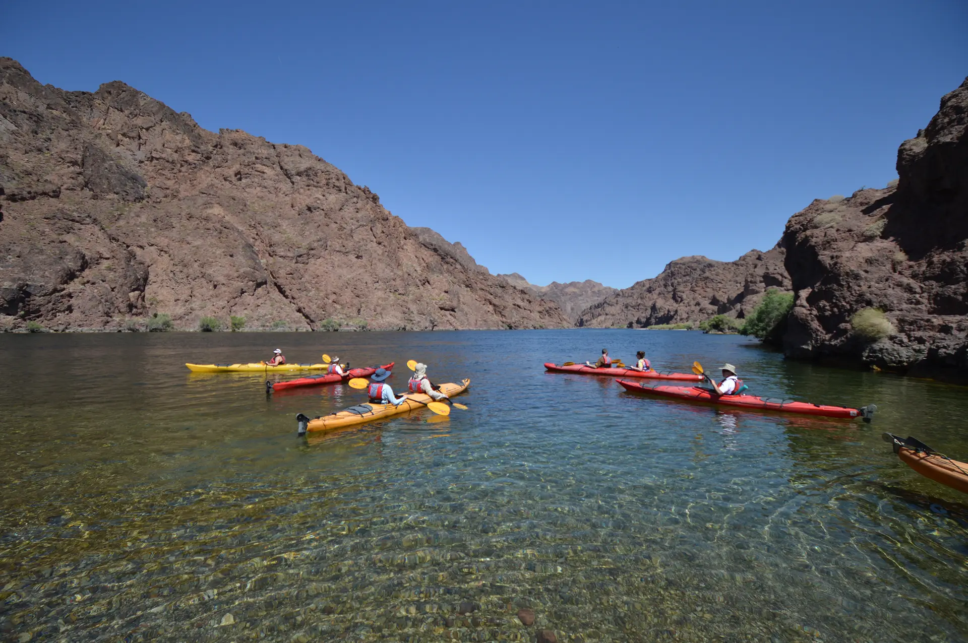 Group of kayakers paddling through clear water in Black Canyon