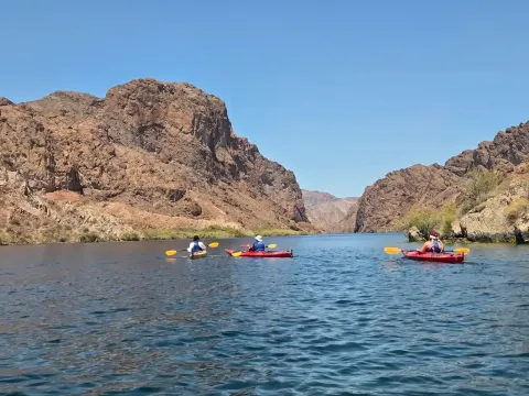 Kayakers paddling beneath the towering walls of Black Canyon