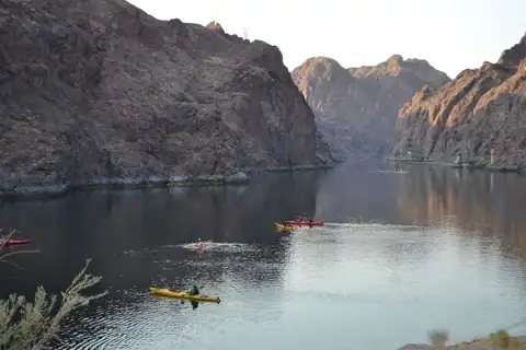 Overview of kayakers paddling through Black Canyon at golden hour