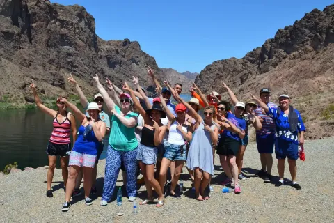 A large group celebrating together beside the Colorado River