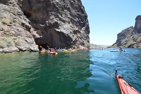 Kayaks entering the glowing emerald cave