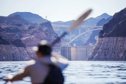 Paddler heading toward Hoover Dam on Lake Mead
