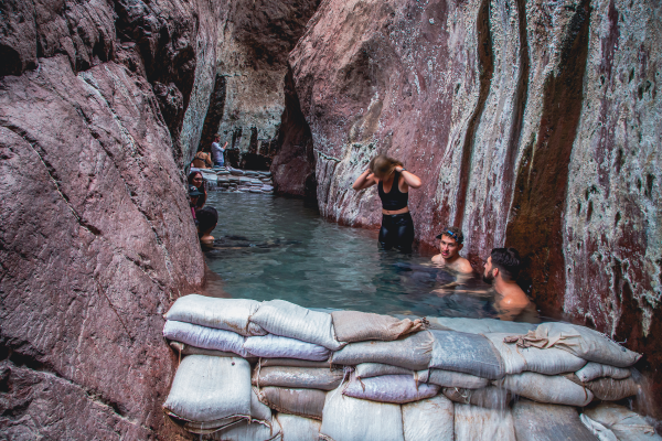 Several people enjoying the natural hot springs near the Emerald Cave.