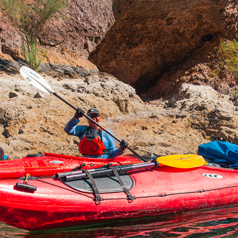 A kayaker smiling and posing with his kayak.
