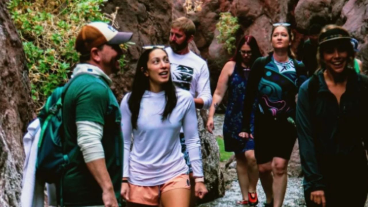Hikers walking through a canyon trail with rocky walls as part of the Evolution Expeditions hot springs tour guided hike