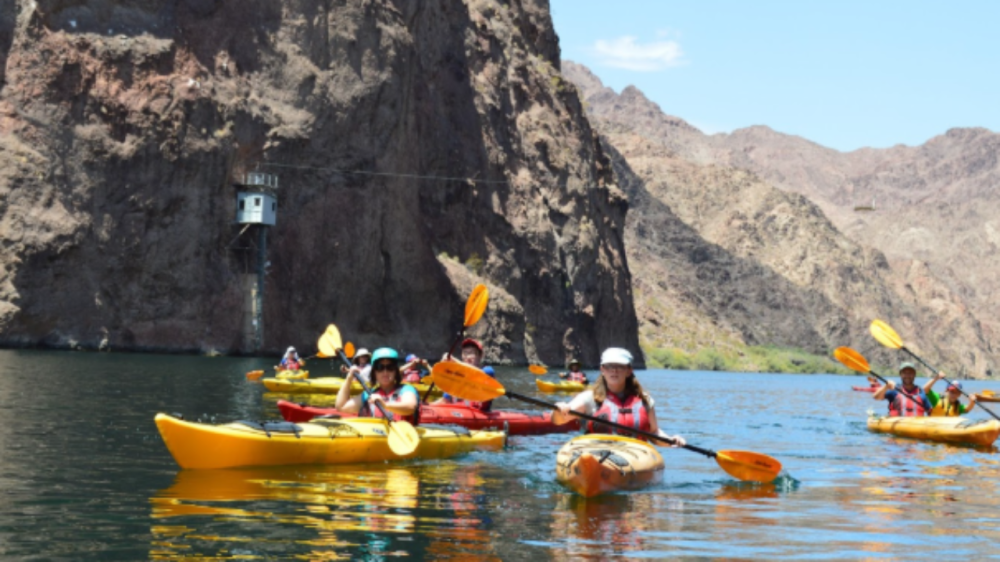 Kayakers paddling on calm waters during a guided tour by Evolution Expeditions
